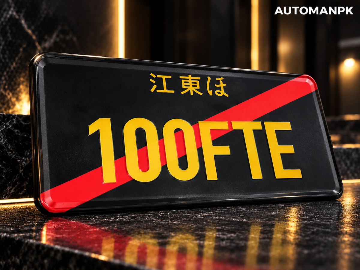 Close-up of a black Japan-style custom car name plate with gold lettering and a red diagonal accent