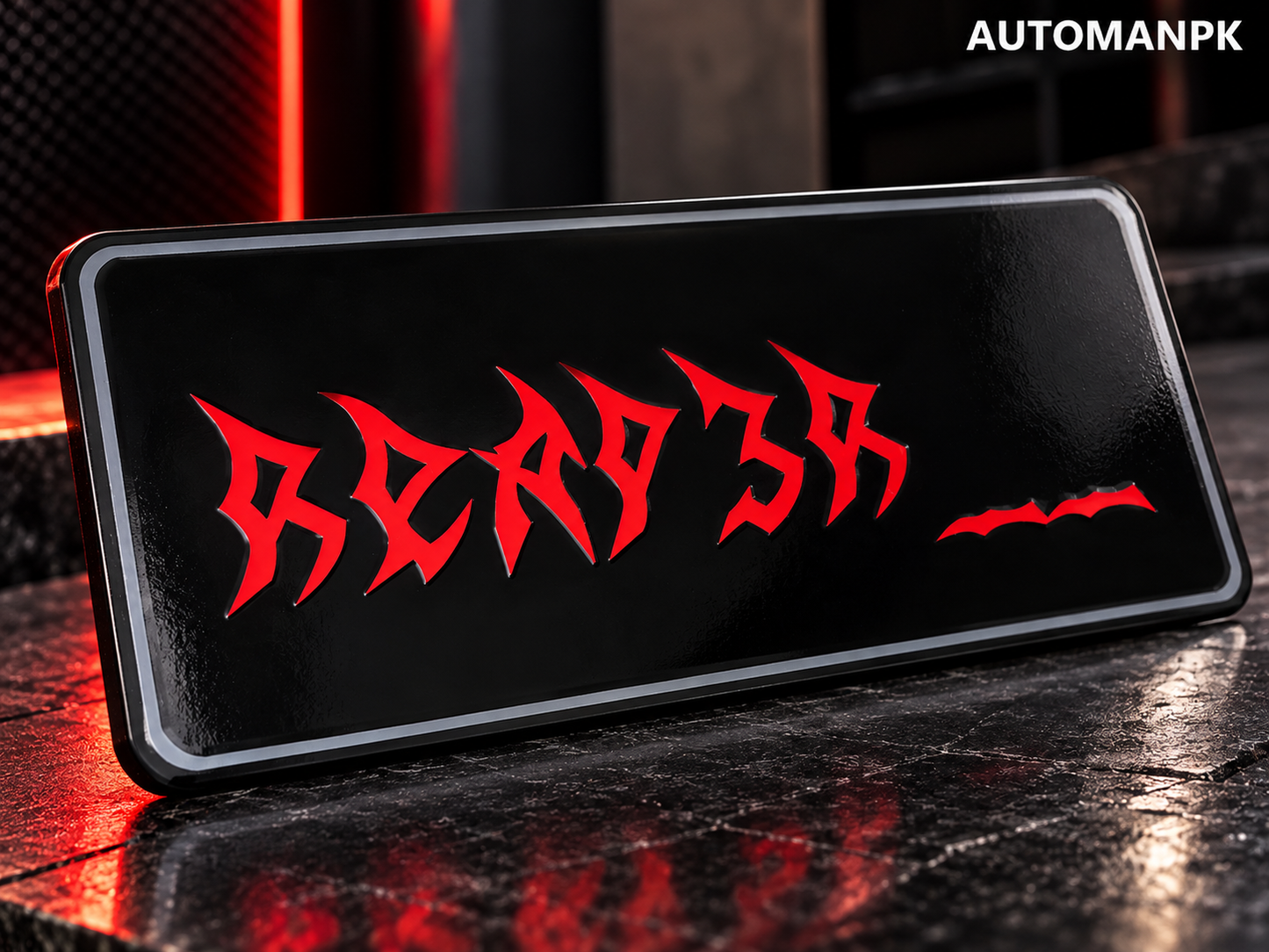 Close-up of a black steel Monster style custom car name plate